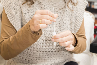 Midsection of woman holding self-testing kit