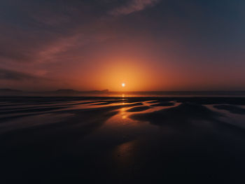 Scenic view of beach against sky during sunset