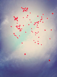 Low angle view of red balloons against sky