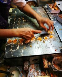 Cropped hands preparing food in kitchen