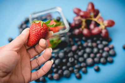 Close-up of hand holding strawberry