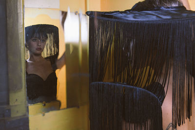 Portrait of woman looking through glass window