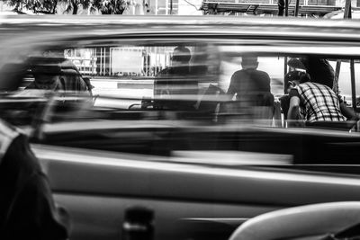 Blurred motion of people on car in city