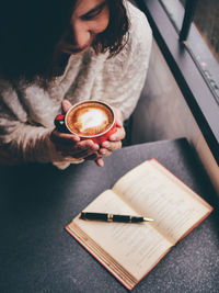 High angle view of woman holding coffee cup