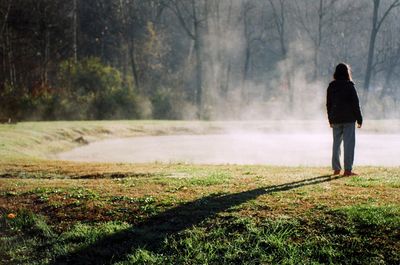 Rear view of woman standing on grass