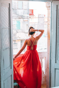 Rear view of woman standing against window