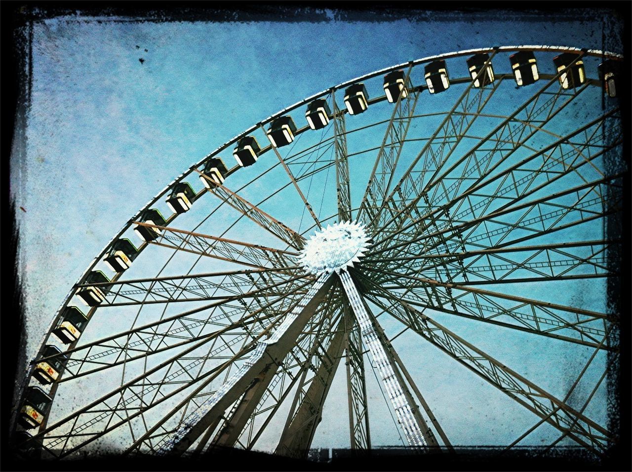 ferris wheel, amusement park, amusement park ride, low angle view, arts culture and entertainment, built structure, sky, architecture, metal, circle, pattern, large, silhouette, day, big wheel, metallic, outdoors, no people, geometric shape, cloud - sky