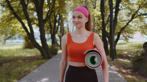 Portrait of young woman standing in park