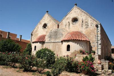 Plants by historic building against clear sky