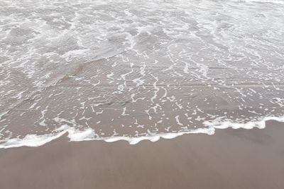 High angle view of waves rushing towards shore