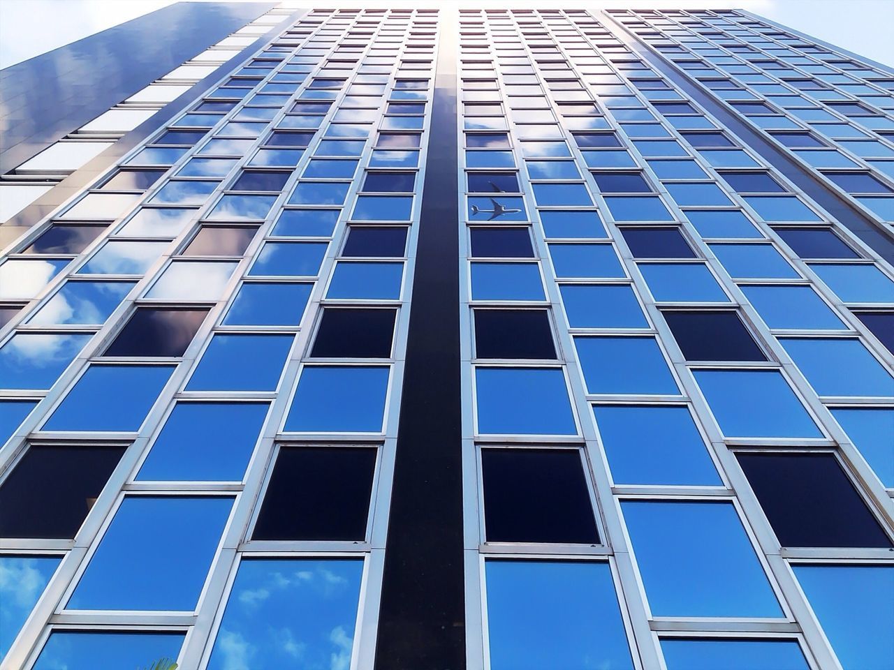 architecture, building exterior, built structure, low angle view, modern, office building, glass - material, city, reflection, skyscraper, window, tall - high, building, tower, clear sky, day, glass, repetition, outdoors, no people