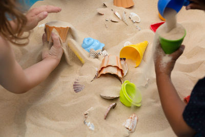 High angle view of siblings playing with toy on sand