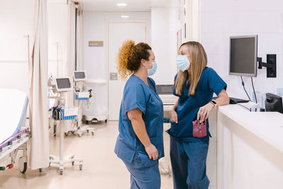 Mature nurse talking to colleague at hospital