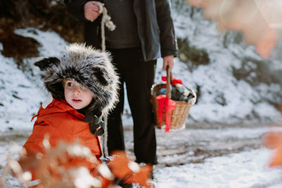 People in snow, child with grandpa holding the basket