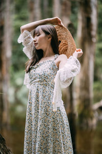 Portrait of young woman wearing hat standing outdoors