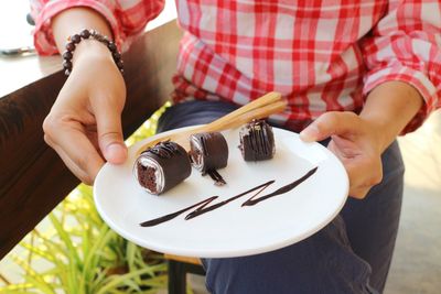 Midsection of woman holding ice cream in plate