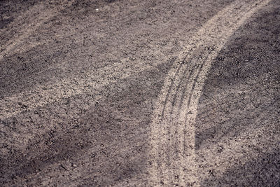 High angle view of tire tracks on road