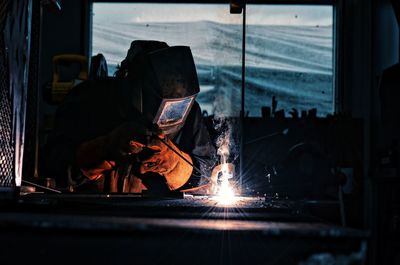 Rear view of man working at night