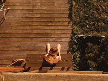High angle view of woman sitting on bench