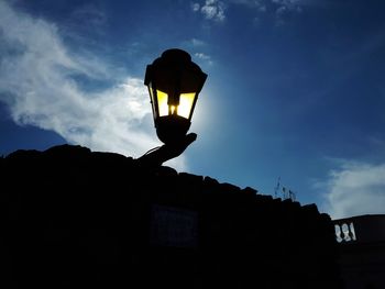 Low angle view of illuminated street light against building