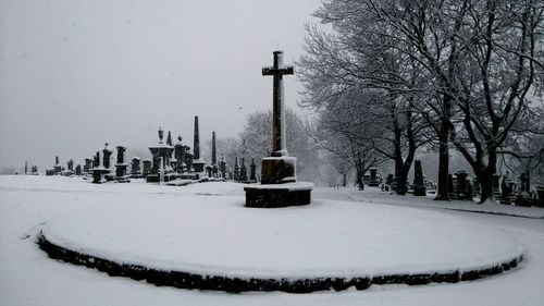 Tombstones at snowcapped cemetery during winter