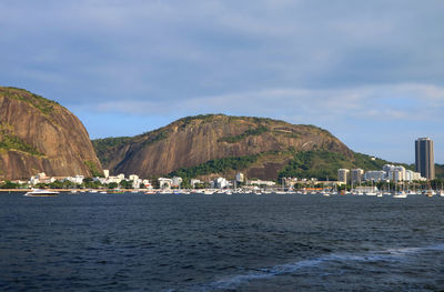 Scenic view of sea and mountains against sky