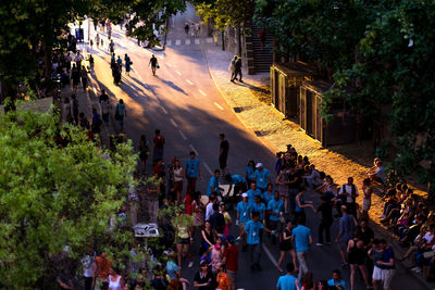 High angle view of people walking by trees in city