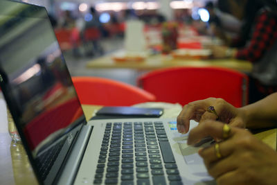 Close-up of hand using laptop on table