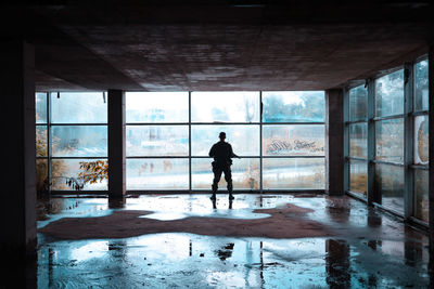 Rear view of silhouette man standing in building