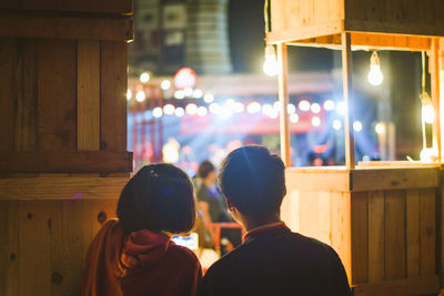 Rear view of couple at illuminated market