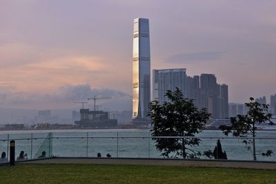 Modern buildings in city against sky during sunset