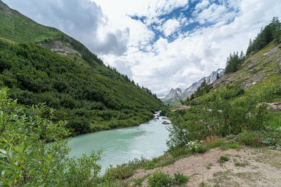 Scenic view of river amidst mountains against sky