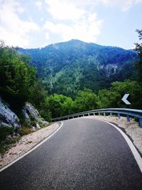 Road amidst trees against sky