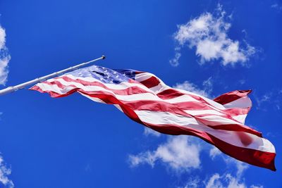 Low angle view of flag against blue sky