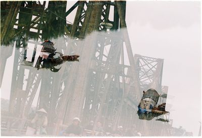 Double exposure of metallic bridge and boats