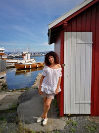 Woman leaning on beach hut at harbor