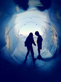 Silhouette of people in tunnel