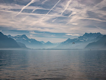 Scenic view of sea and snowcapped mountains against sky