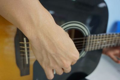 Midsection of man playing guitar