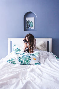 Portrait of woman sitting on bed at home