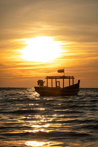 Silhouette boat in sea against sky during sunset