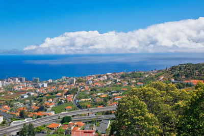 High angle view of townscape by sea against sky