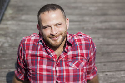 Portrait of man sitting on wood