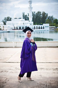 Portrait of woman standing against built structure