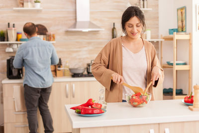 Woman making salad in kitchen