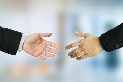 Cropped hands of business colleagues reaching towards each other