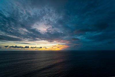 Scenic view of sea against dramatic sky during sunset