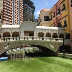 Bridge over river in city against sky