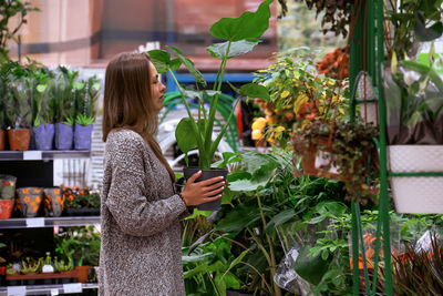 Side view of woman standing at florist shop