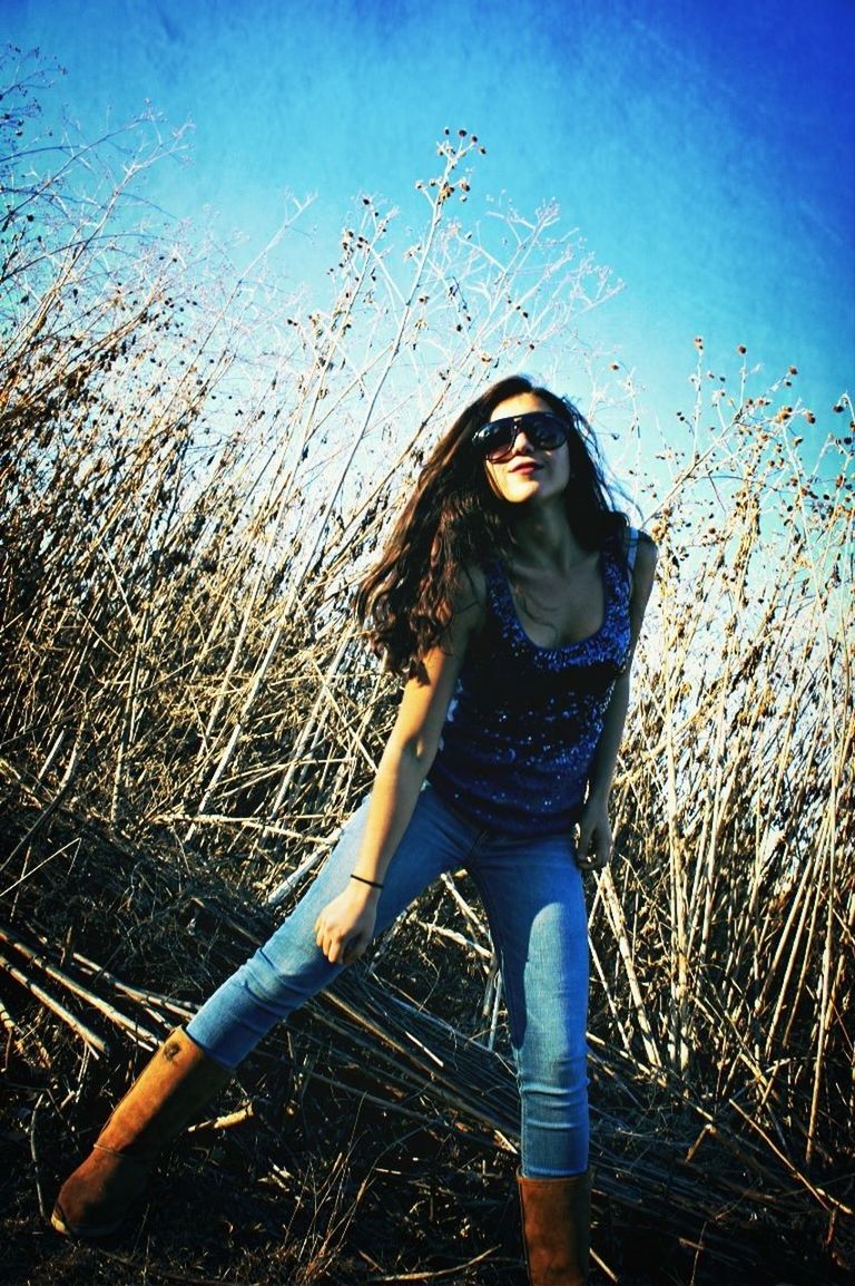 person, lifestyles, young adult, looking at camera, leisure activity, portrait, casual clothing, young women, standing, front view, long hair, sky, smiling, three quarter length, happiness, full length, field